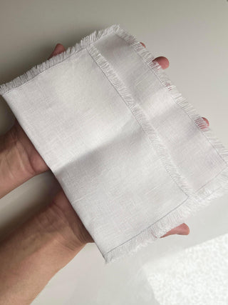 mīkstināta lina sejas dvielis rokās