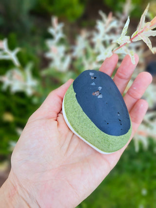 Akmens šī sviesta dabīgas ziepes rokās pie ziediem