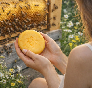Sieviete tur rokās pie bišu stropa dabīgas burkānu sulas un medus ziepes