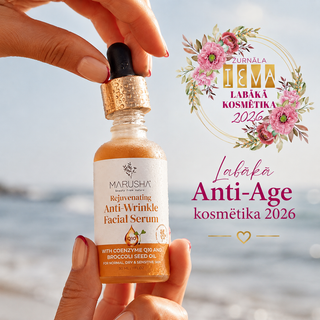 A hand holds a small glass bottle of Marusha Rejuvenating Anti-Wrinkle Facial Serum with a gold glitter dropper cap against a blurred beach background. The bottle contains an amber liquid with visible gold flakes.