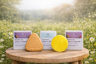 Marusha Kadiķa un rozmarīna un hibiskus cietie šampūni un cietais matu kondicionieris uz koka galda ar kastītēm un pļava fonā 