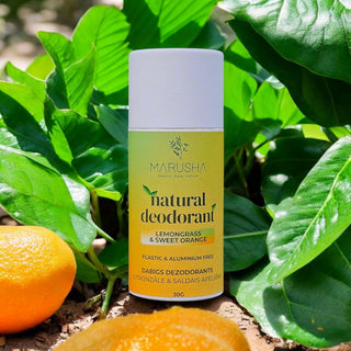 Marusha natural deodorant bottle with lemongrass and sweet orange scent on a green leafy background