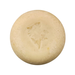 Round beige bar of soap with a star design on a white background