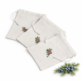 Set of three linen bags with embroidered holly designs on a white background.