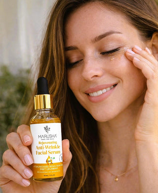 Woman applying facial serum with a Marusha bottle in the foreground