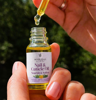 Marusha Nagu un kutikulu eļļa rokās ar atvērtu pipeti un eļļas pilītēm