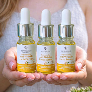 Marusha dabīga sejas serums trīs pudelītes sievietei rokās