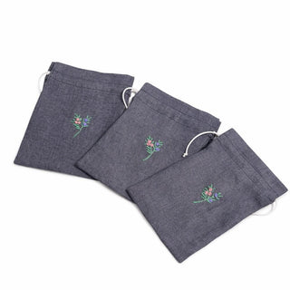 Three dark gray pouches with floral embroidery on a white background