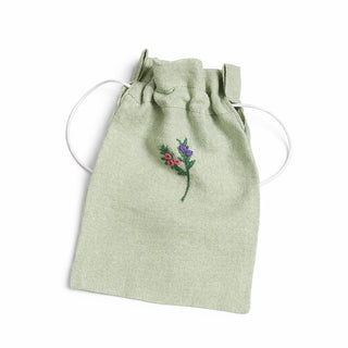 Light green drawstring pouch with floral embroidery on a white background